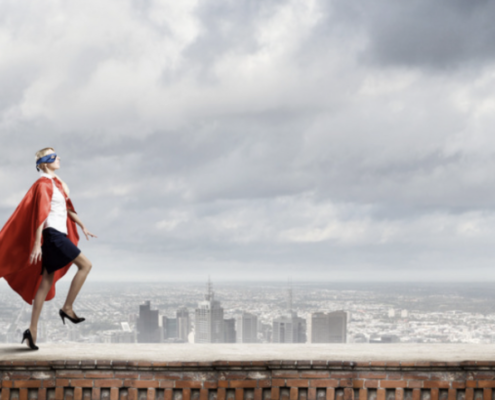 Business person in superhero pose overlooking a cityscape, symbolizing the strength and flexibility of cloud infrastructure to support and elevate businesses in dynamic environments.